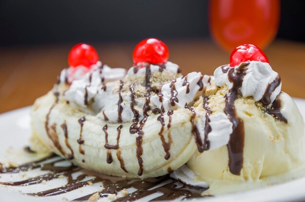 Closeup de deliciosa sobremesa de banana split e copo de cerveja de framboesa