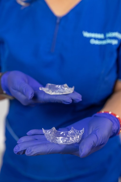 Closeup de dentista segurando contenção para tratamento oral em seu consultório