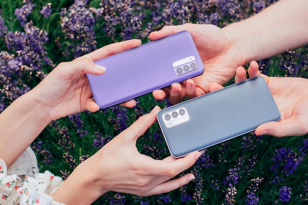 Foto closeup de dois telefones em mãos masculinas e femininas contra um fundo de flores