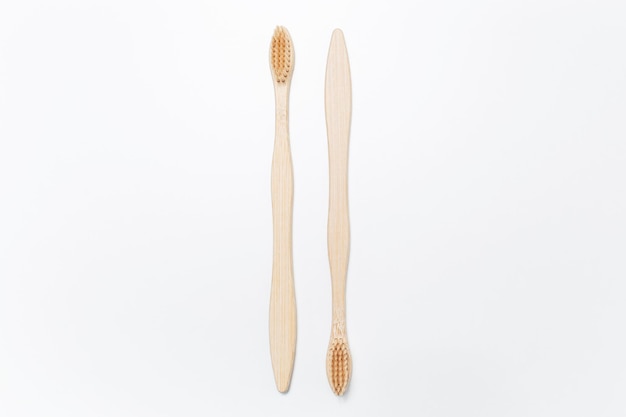 Closeup de duas escovas de dentes de bambu isoladas no fundo branco
