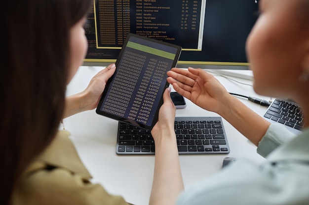 Closeup de duas mulheres jovens segurando tablet digital com espaço de cópia de código