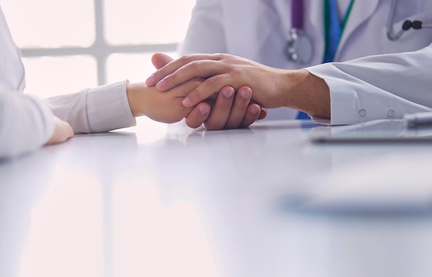 Closeup de estetoscópio e papel no fundo das mãos do médico e do paciente