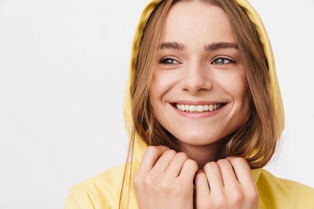 Closeup de foto de mulher bonita alegre em capa de chuva, olhando para a câmera e sorrindo