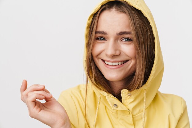 Closeup de foto de mulher bonita alegre em capa de chuva, olhando para a câmera e sorrindo