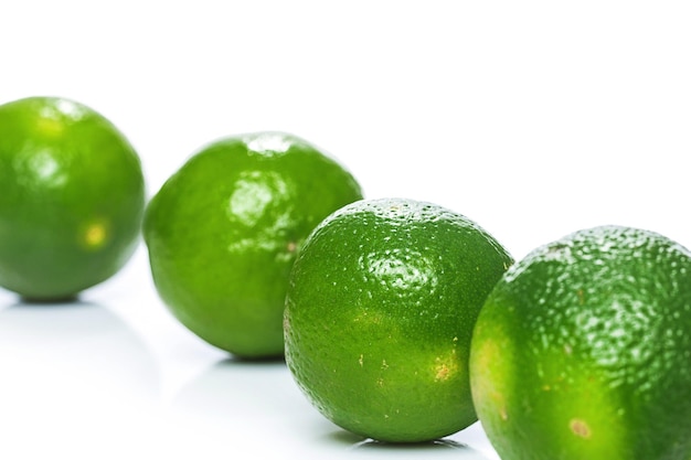 Closeup de frutas frescas de limão verde sobre fundo branco