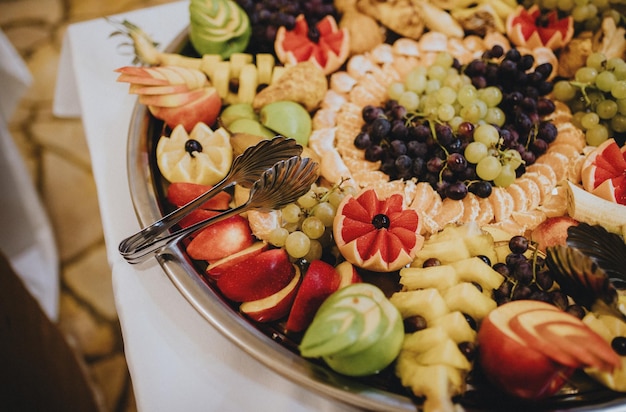 Closeup de frutas lindamente decoradas em uma bandeja grande, bandeja de festa de frutas