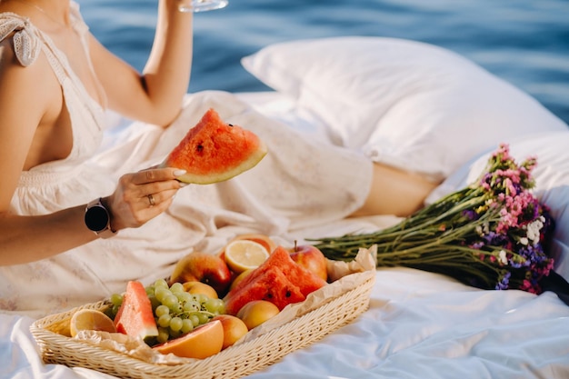 Closeup de frutas variadas em uma bandeja A menina leva a fruta em suas mãos