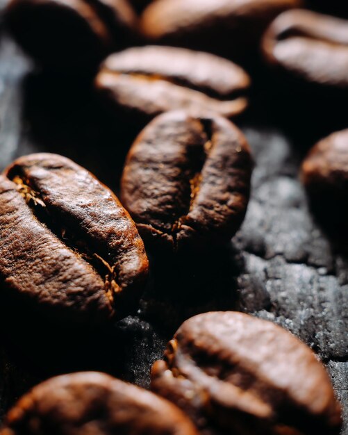 Closeup de grãos de café foco seletivo macro foto de café em fundo textural escuro