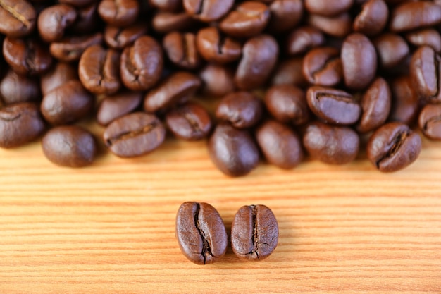 Closeup de grãos de café torrados de Arábica VS Robusta com a pilha de grãos de café borrados