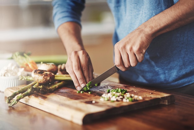 Closeup de homem cozinhando na cozinha preparando comida com legumes frescos almoço caseiro por vegetariano aprendendo a equilibrar a nutrição para um estilo de vida saudável nutricionista faz refeição orgânica sem glúten