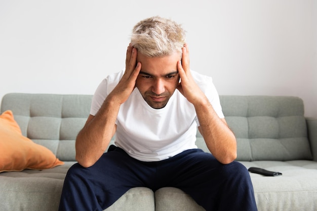 Closeup de homem hispânico deprimido sentado no sofá Conceito de depressão