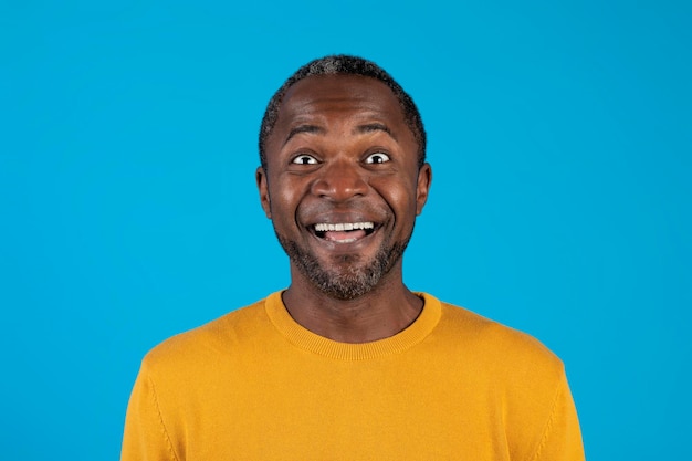 Closeup de homem negro animado sorrindo isolado em azul