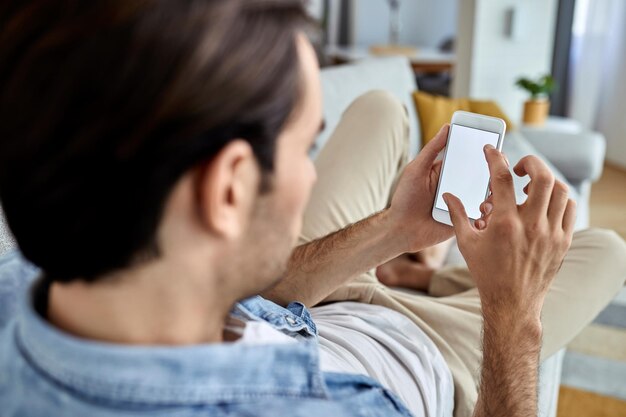 Closeup de homem usando telefone celular enquanto relaxa em casa Copie o espaço