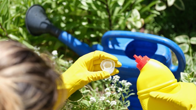 Closeup de jardineira feminina usando fertilizante para plantas para rega jardinagem e melhoria
