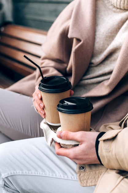 Closeup de jovem casal em viver tendo um copo take away com café quente