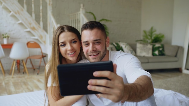 Closeup de jovem casal fofo e amoroso conversando por vídeo segurando smartphone e conversando