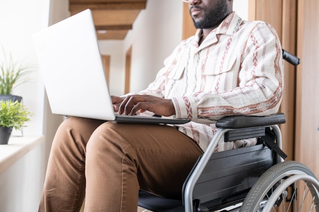 Closeup de jovem com deficiência trabalhando na rede em home office