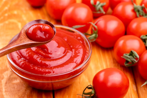 Closeup de ketchup e tomate em um fundo de madeira