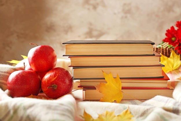 Closeup de livros e maçãs de outono em cima da mesa