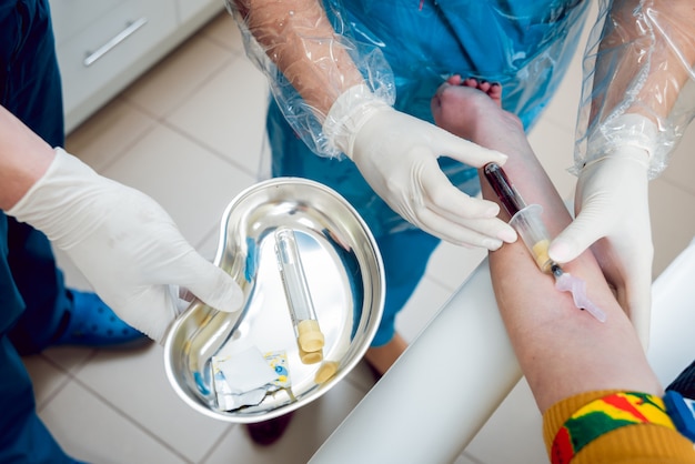 Closeup de mãos da enfermeira tirando uma amostra de sangue