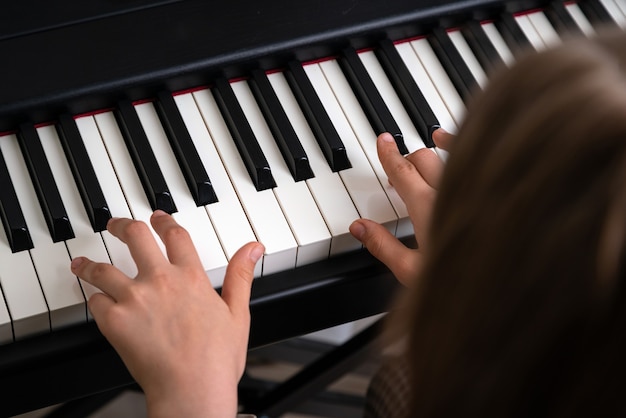 closeup de mãos de adolescentes tocando piano em estúdio de música em casa
