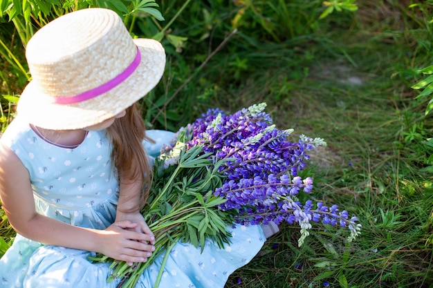 closeup de mãos de mulheres segurando um buquê com flores silvestres. Flores de verão violeta. Campo de tremoço. Provence. Menina detém grande buquê de tremoços roxos no campo de flores. Conceito de natureza. Presente