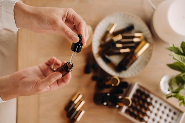 Closeup de mãos femininas segurando uma garrafa de aromaterapia de óleo essencial