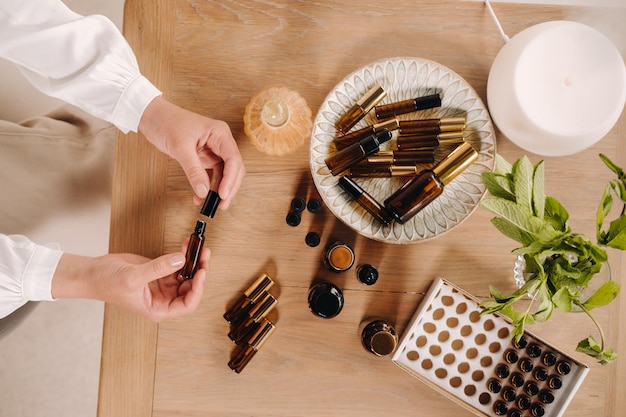 Closeup de mãos femininas segurando uma garrafa de aromaterapia de óleo essencial