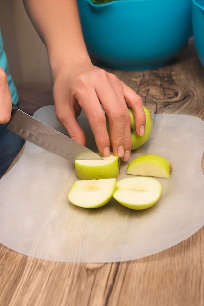 Closeup de mãos na garota latina cortando maçãs verdes