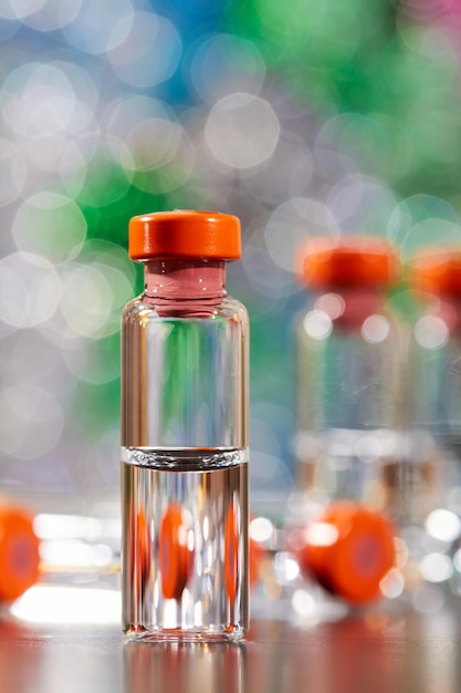 Closeup de medicamento para injeção em frascos de vidro em um fundo colorido