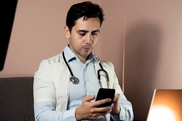 Closeup de médico usando telefone em seu consultório médico trabalhando online