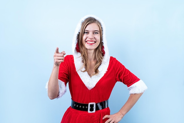 Closeup de mulher caucasiana feliz vestindo roupas de papai noel apontando para a câmera