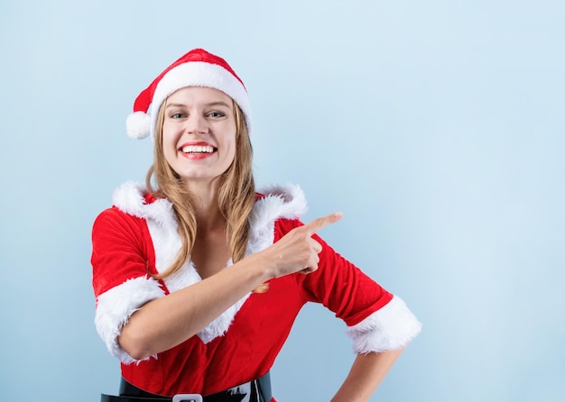 Closeup de mulher caucasiana feliz vestindo roupas de papai noel rindo e apontando o dedo