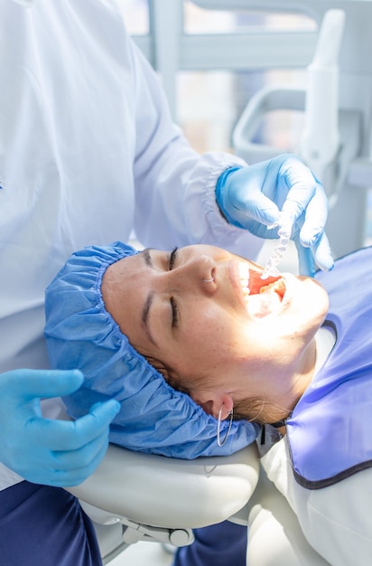 Closeup de mulher com a boca aberta em uma clínica odontológica com um dentista para colocar um aparelho dental transparente Conceito de clínica odontológica