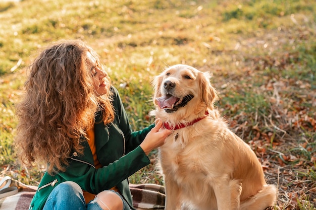 Closeup de mulher encaracolada sentada com seu cachorro na temporada de primavera