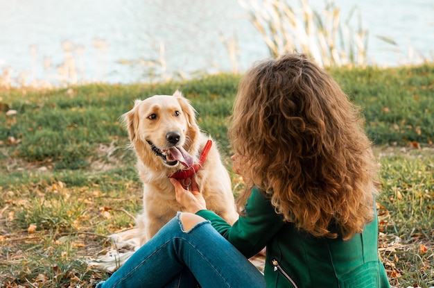 Foto closeup de mulher encaracolada sentada com seu cachorro na temporada de primavera