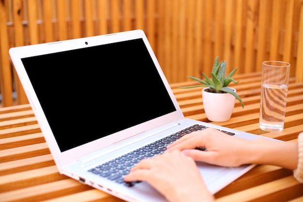 Closeup de mulher irreconhecível digitando no teclado do laptop enquanto trabalhava em exibição remota de trabalho remoto ao ar livre com espaço de cópia para área de anúncio para texto promocional