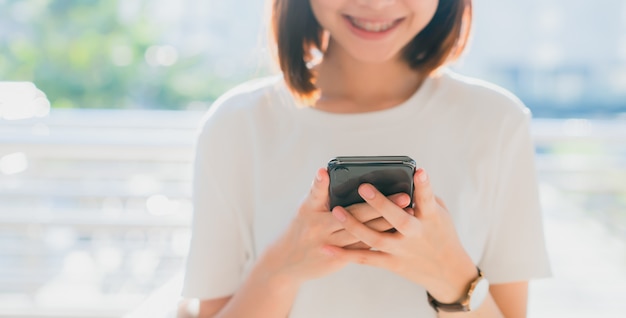 Closeup de mulher segurando um smartphone, mock-se da tela em branco. usando o celular no estilo de vida. tecnologia para o conceito de comunicação.