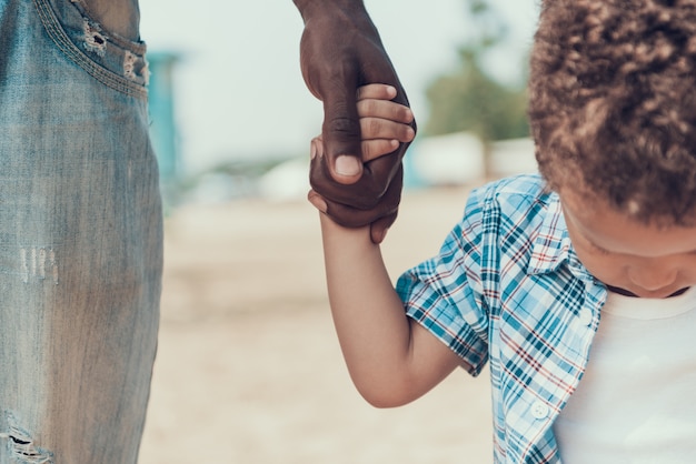 Closeup de pai afro-americano e filho é de mãos dadas