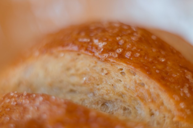 Foto closeup de pão pão de massa fermentada acabado de fazer com uma crosta dourada nas prateleiras da padaria. padaria conte