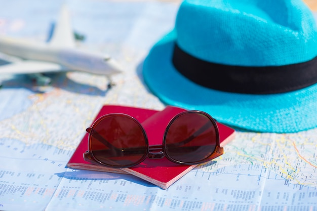 Closeup de passaportes, avião de brinquedo, óculos de sol no mapa