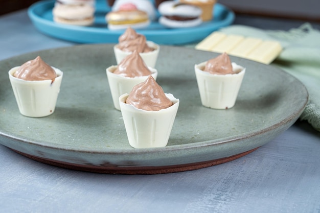 Closeup de pequenos copos de chocolate branco cheios de mousse de chocolate ao leite