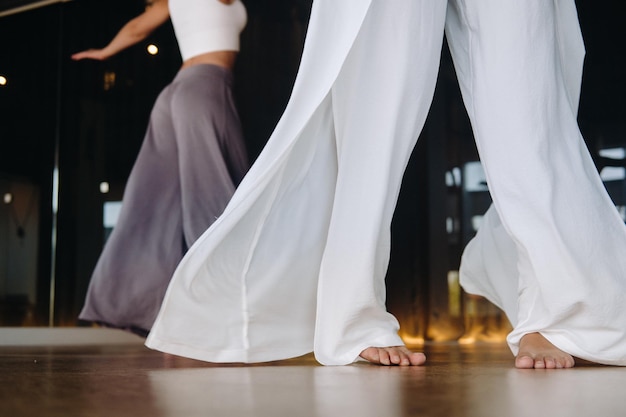 Foto closeup de pernas dançantes de mulheres em roupas esportivas fazendo ioga de dança no ginásio