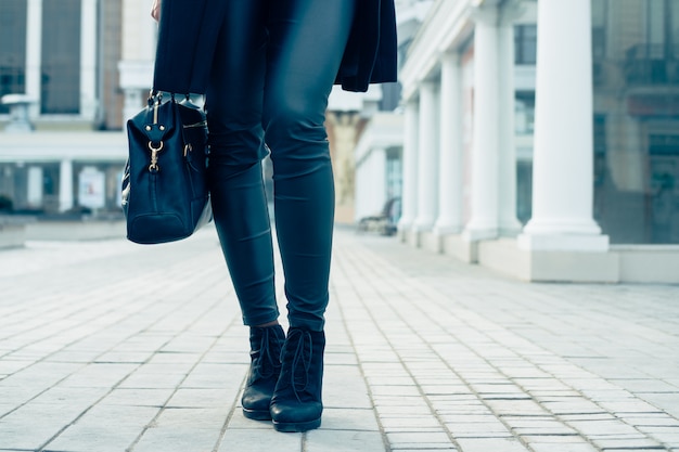 Closeup de pernas femininas em calças pretas e botas