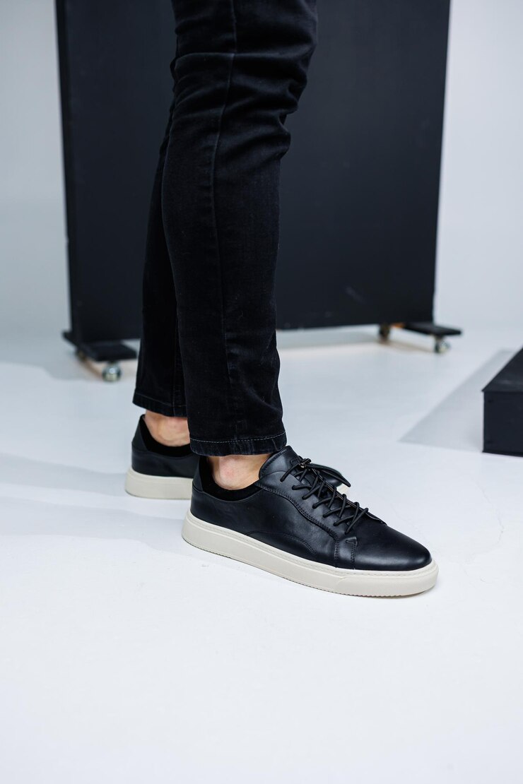 Foto closeup de pernas masculinas em tênis casuais de couro preto sapatos masculinos confortáveis de meia estação