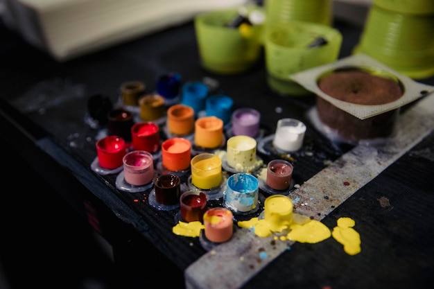 Closeup de pigmento de tatuagem de cores diferentes em caixas em agulhas