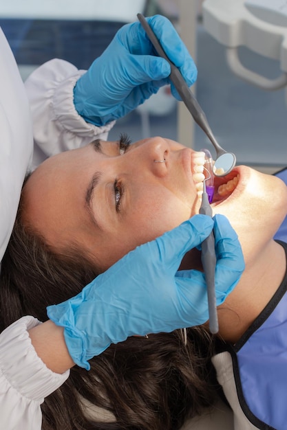 Closeup de rosto jovem sendo examinado pelo dentista na clínica odontológica