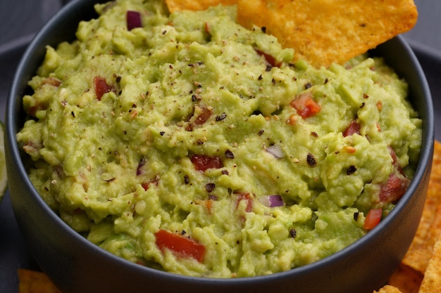 Closeup de saboroso mergulho de guacamole fresco em chapa preta