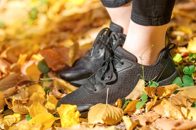 Closeup de sapatos de mulher casual nas folhas de outono