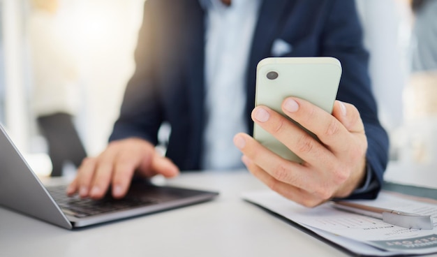 Closeup de telefone e laptop com mãos de homem no escritório para planejamento de pesquisa e rede Tecnologia digital e comunicação com funcionário do sexo masculino para contato conexão on-line e e-mail